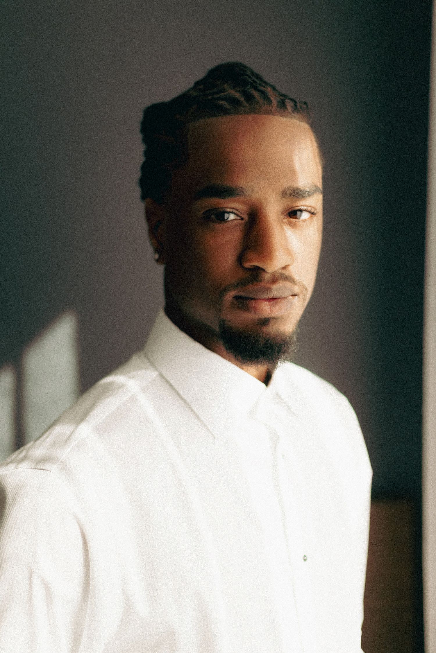 Portrait series showing a person in a white shirt against a dark background with dramatic side lighting.