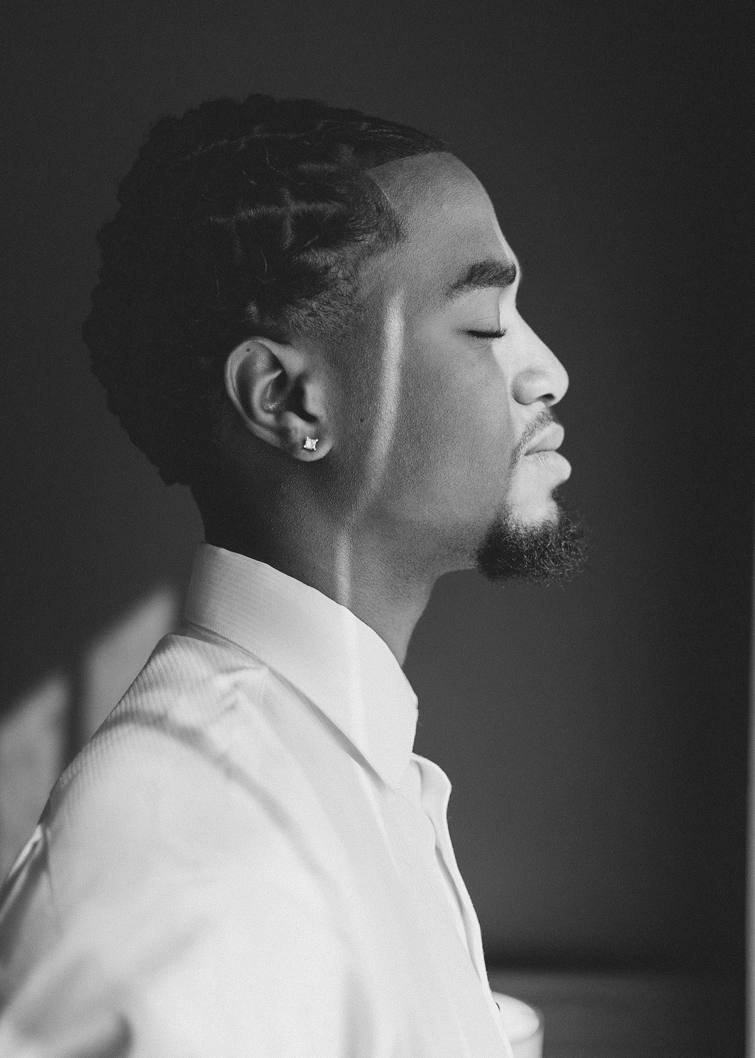 A series of black and white profile portraits showing expressions of joy and laughter in dramatic lighting.