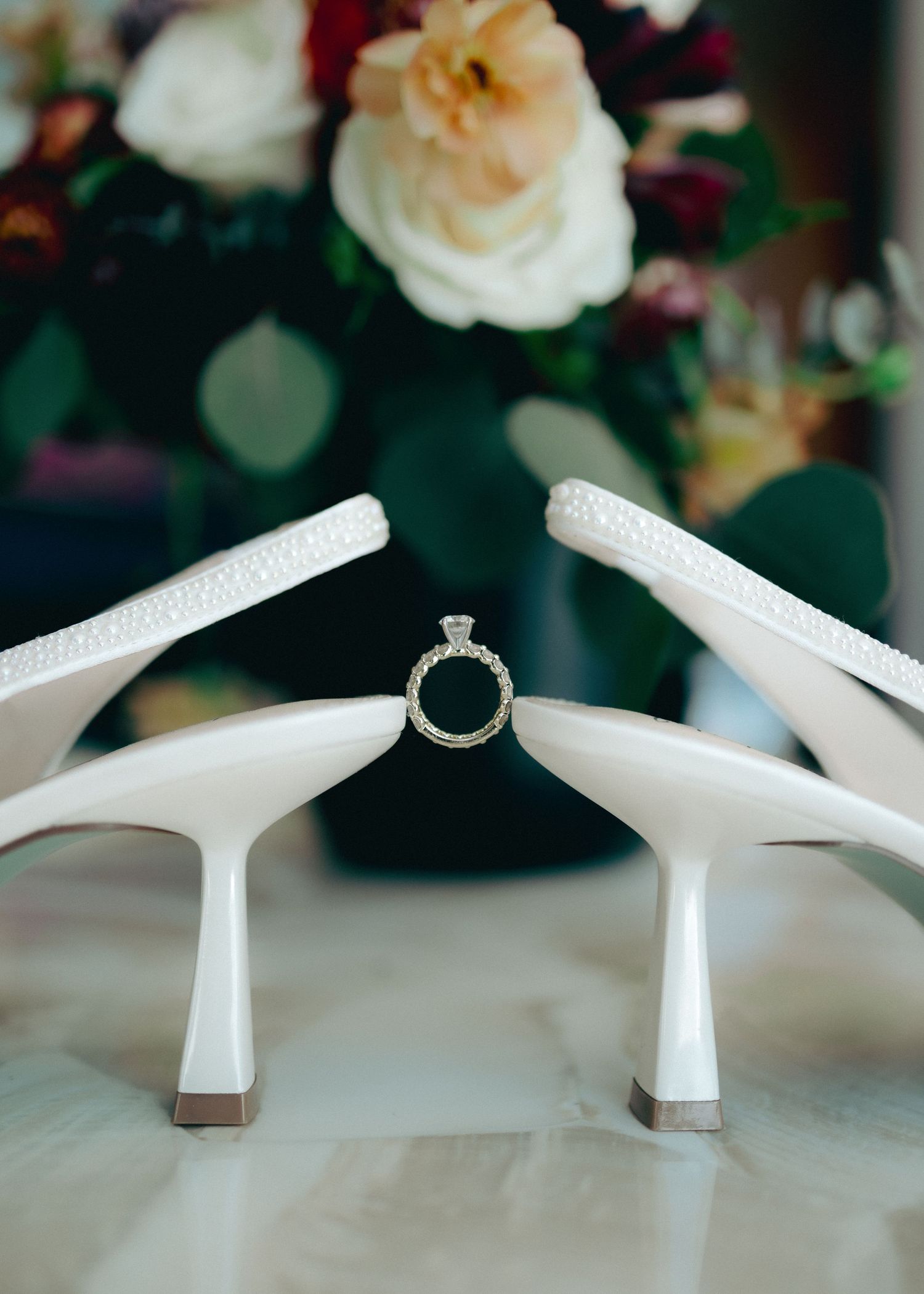 White slingback heels with kitten heel displayed in sequence showing different angles against floral background.