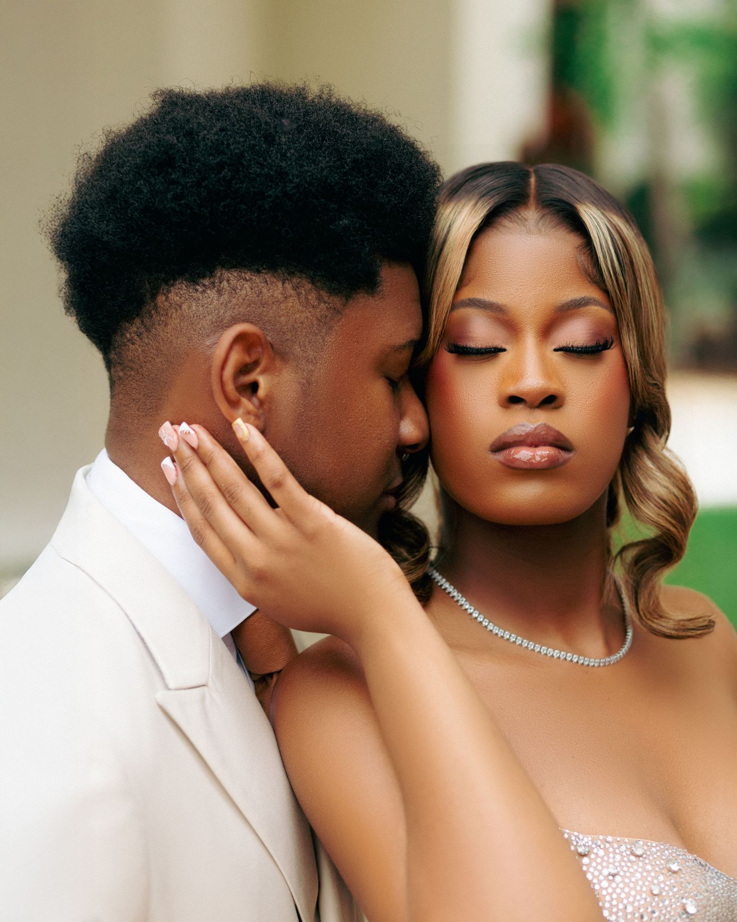 A tender moment captured between a couple in formal attire with soft lighting and elegant styling.