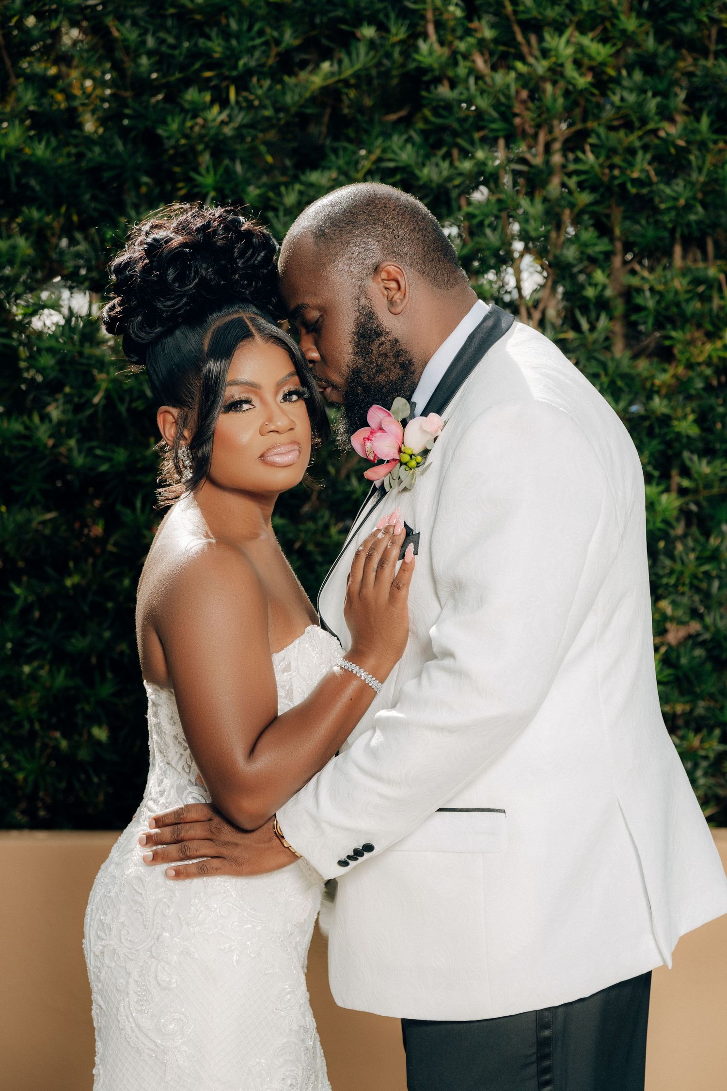 Romantic outdoor wedding portraits with lush greenery background.
