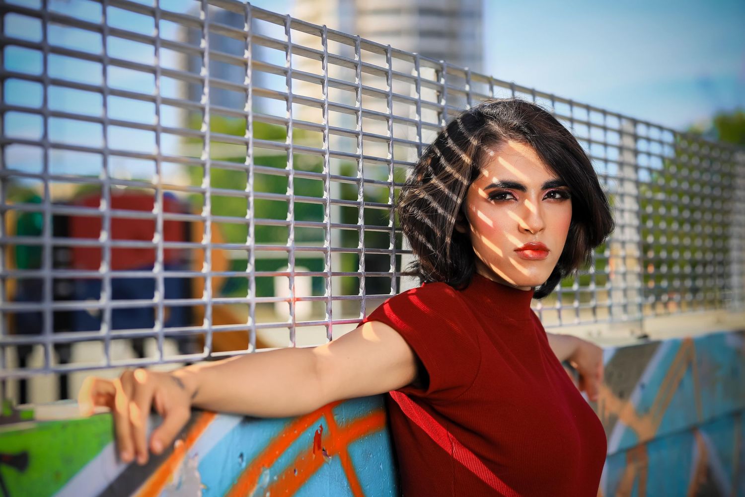 Fashion photoshoot against urban metal grid background with dramatic poses.
