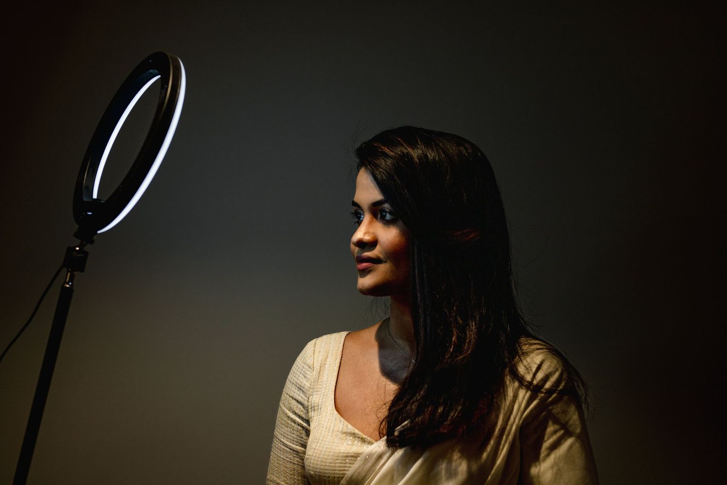 Professional recording studio microphone setup with dramatic lighting and silhouetted figure in profile.