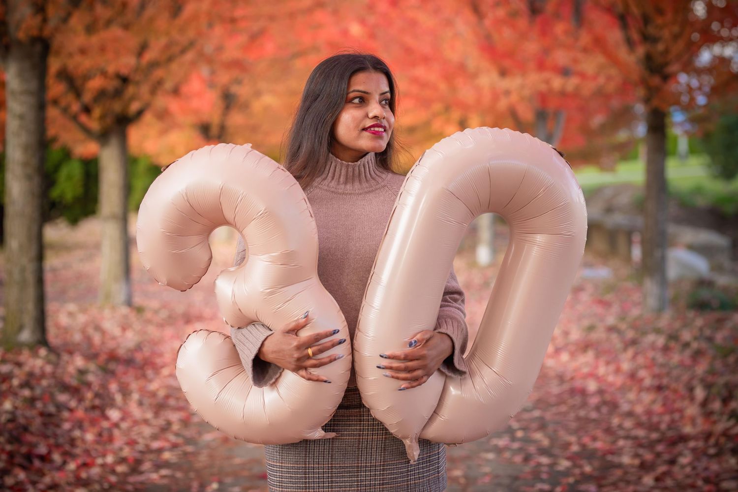 Autumn photo session with decorative inflatable letters against fall foliage background.