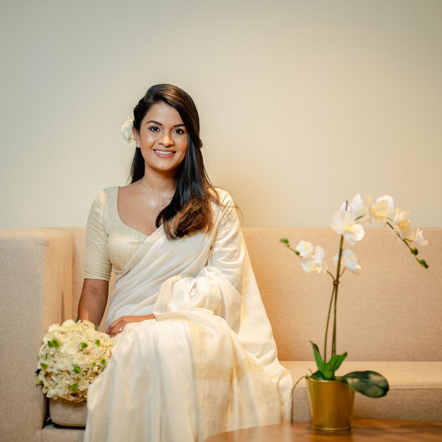 A sequence of maternity photos showing a woman in white dress seated next to orchid flowers in warm lighting.