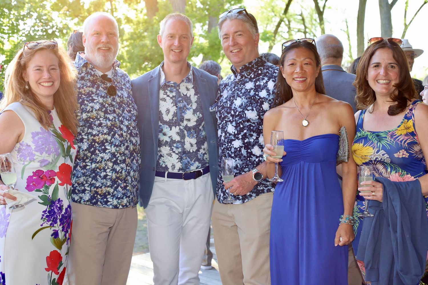 large group of people posing at an outdoor summer event