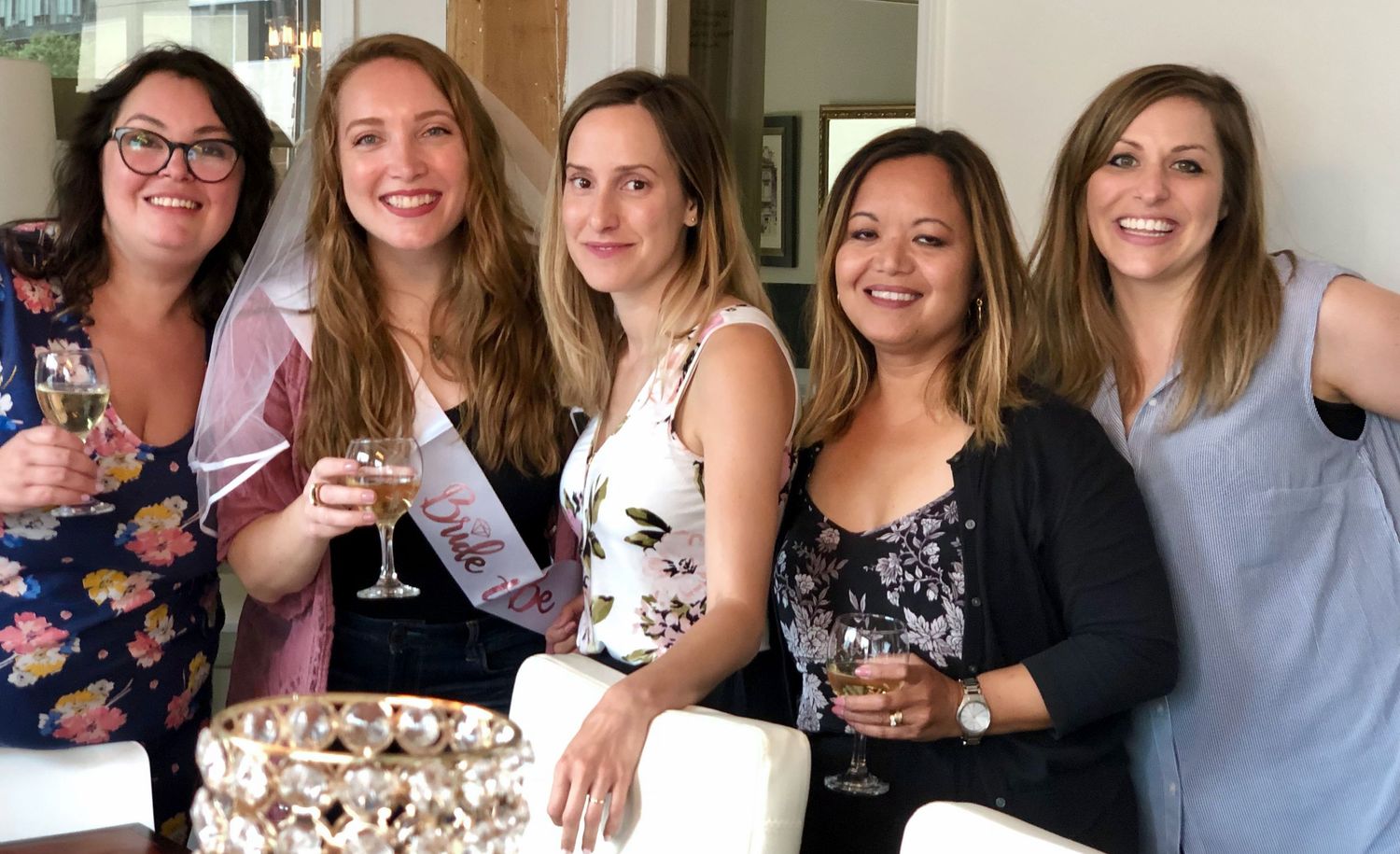 wedding shower event with ladies posing and bride to be is wearing a veil