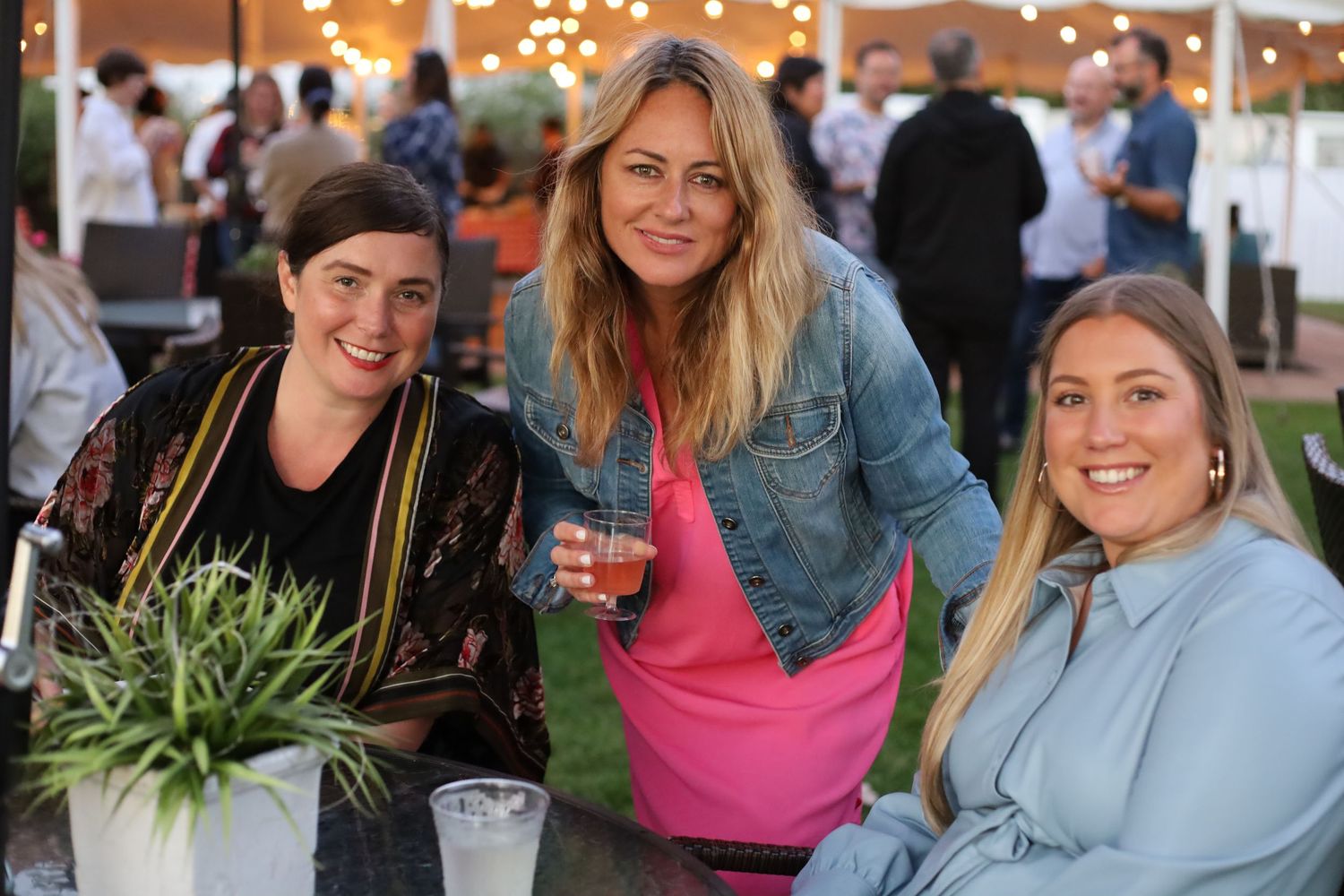 three people posing and smiling at an event