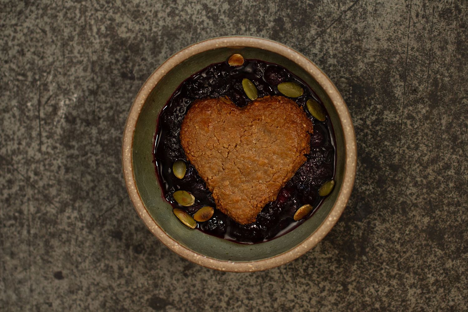 Huckleberry cobbler overhead with heart pastry. Food and beverage, plant-focused photographer, Brigit Steele, B. Steele Images.