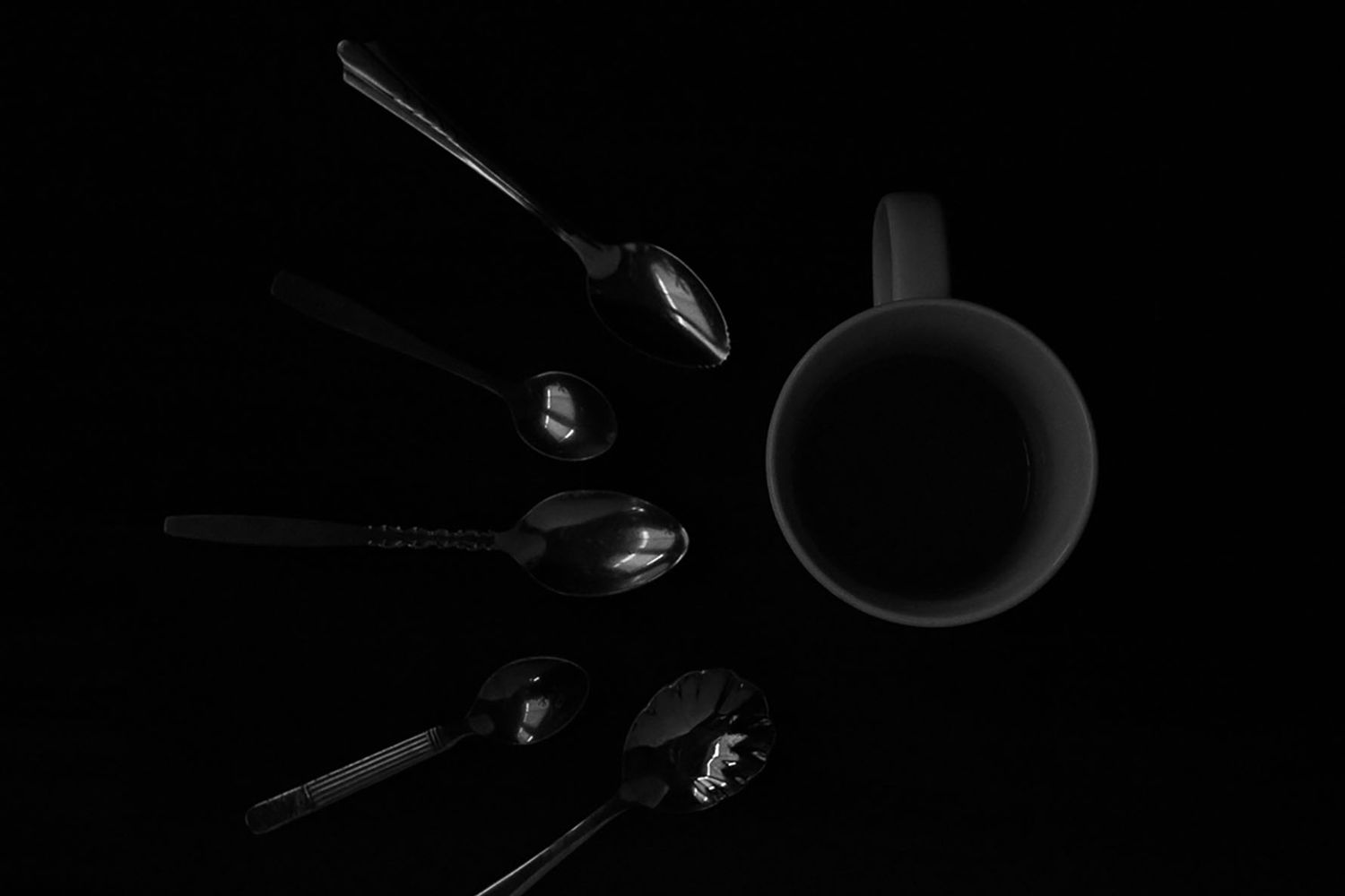 A sequence of spoons around a cup of coffee in black and white. B. Steele Images, food and beverage photography