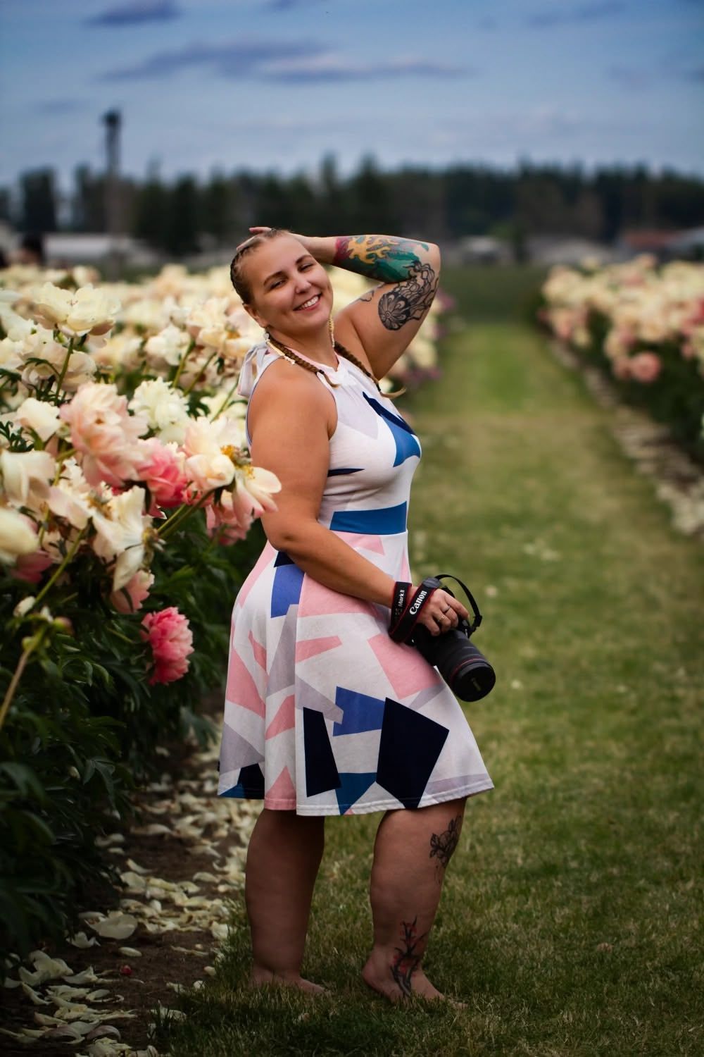 Brigit Steele stands in a blooming flower garden field wearing a patterned dress. B. Steele Images, Oregon food and beverage photographer
