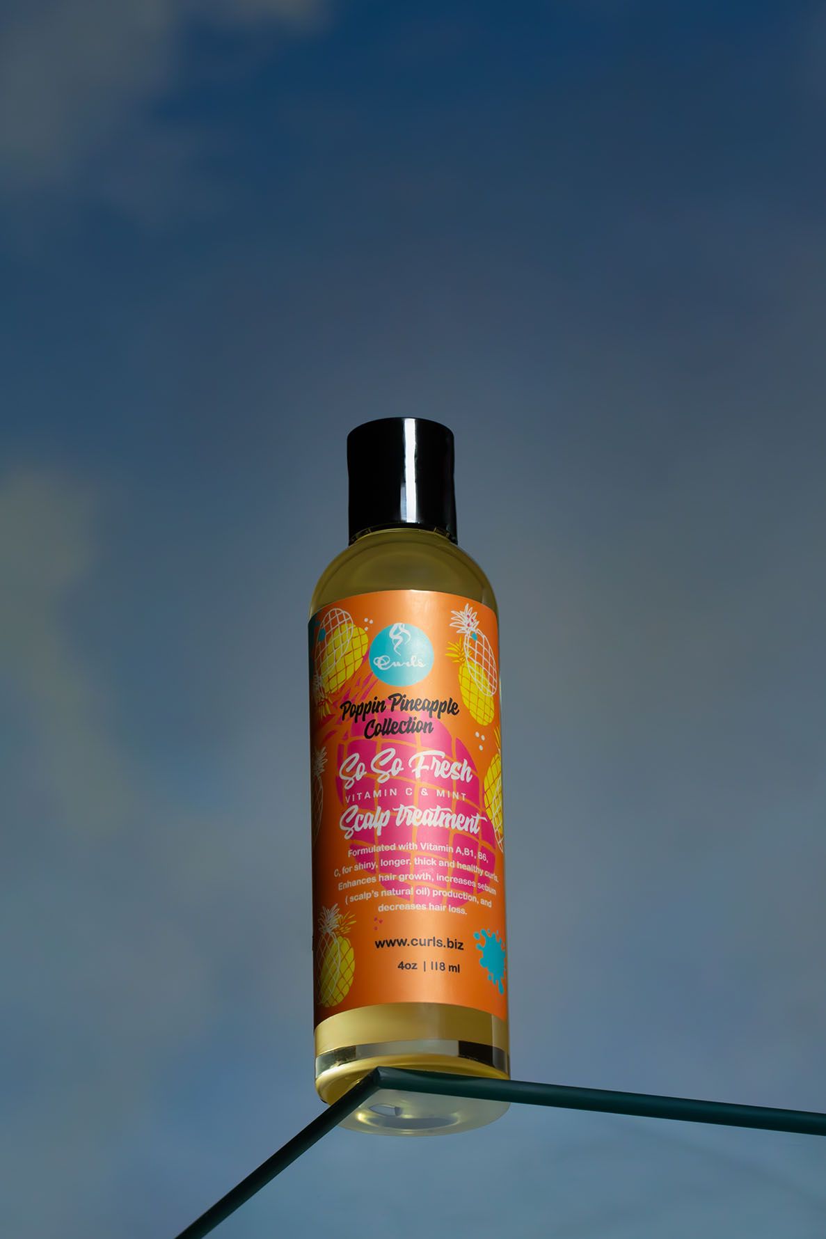 Hair care product bottle against a blue sky background captured from below. B. Steele Images, product photogrpahy
