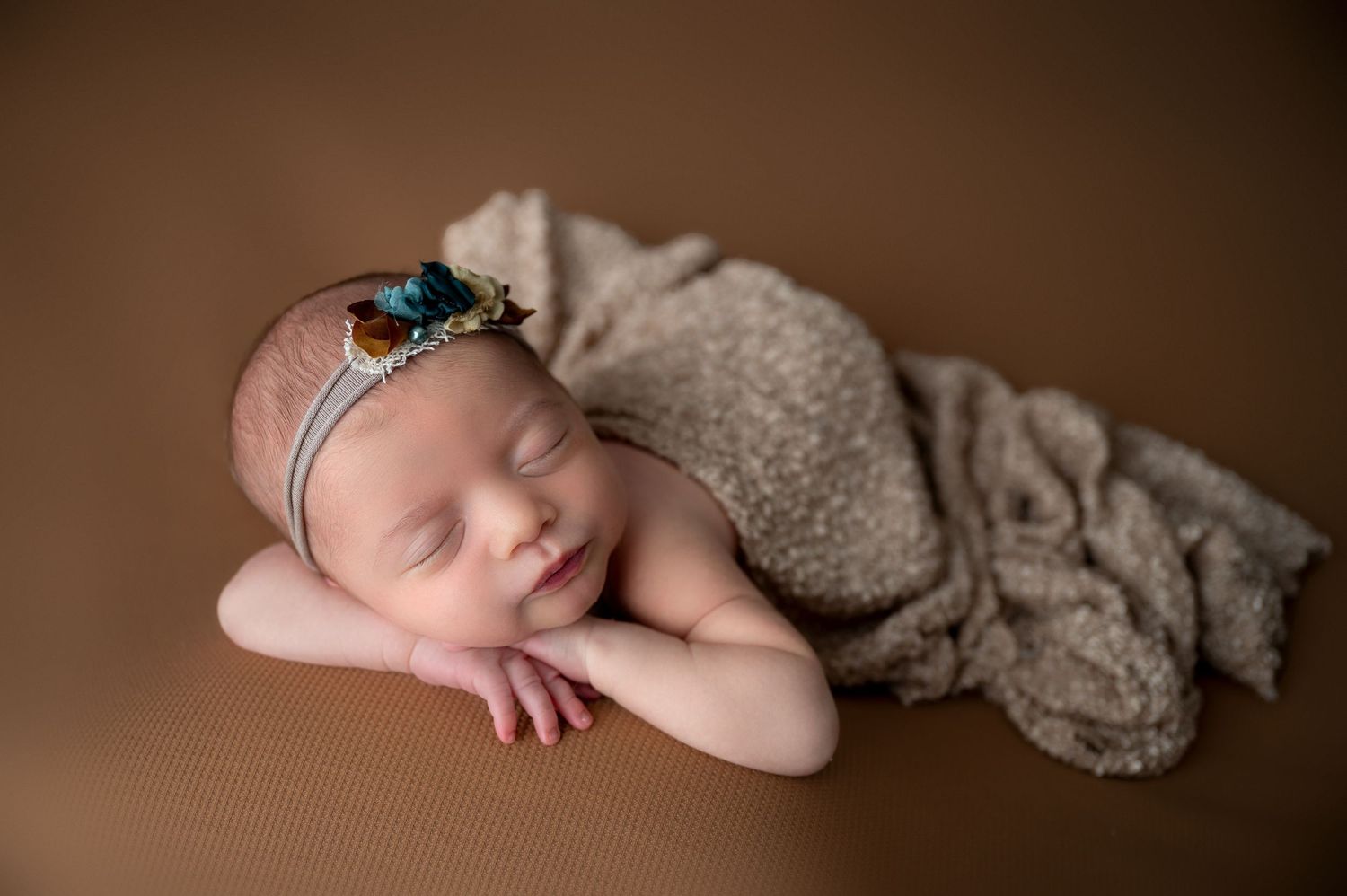 Gentle newborn photography sequence with brown tones and delicate lace accessories.