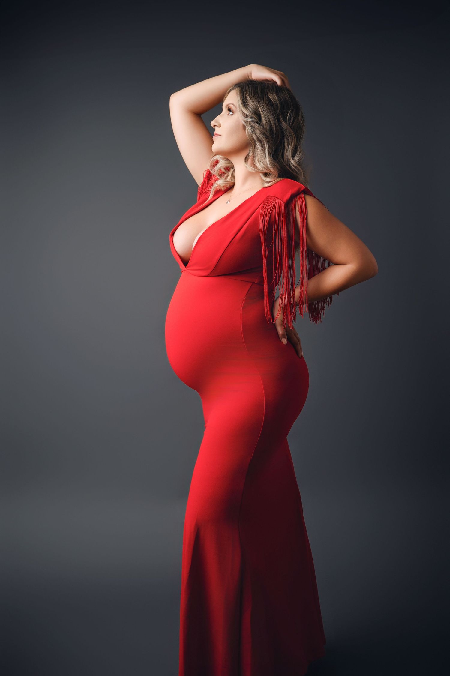 Studio portraits featuring vibrant red dress against dark background with dramatic poses.