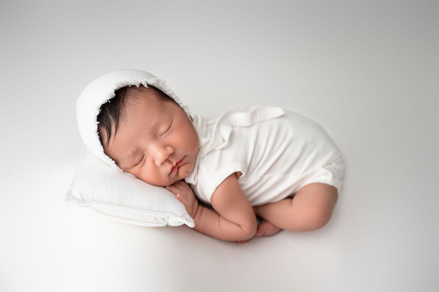 Clean white newborn photography collection with minimalist styling.