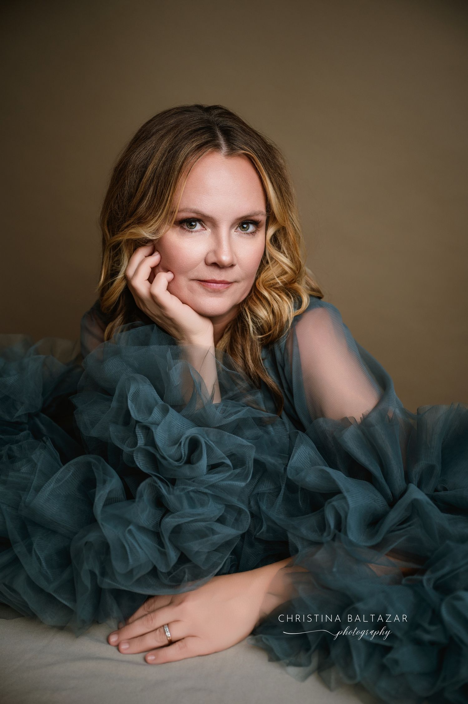 Elegant portrait featuring a woman in a flowing teal tulle gown against a neutral background. Women's Beauty Portrait