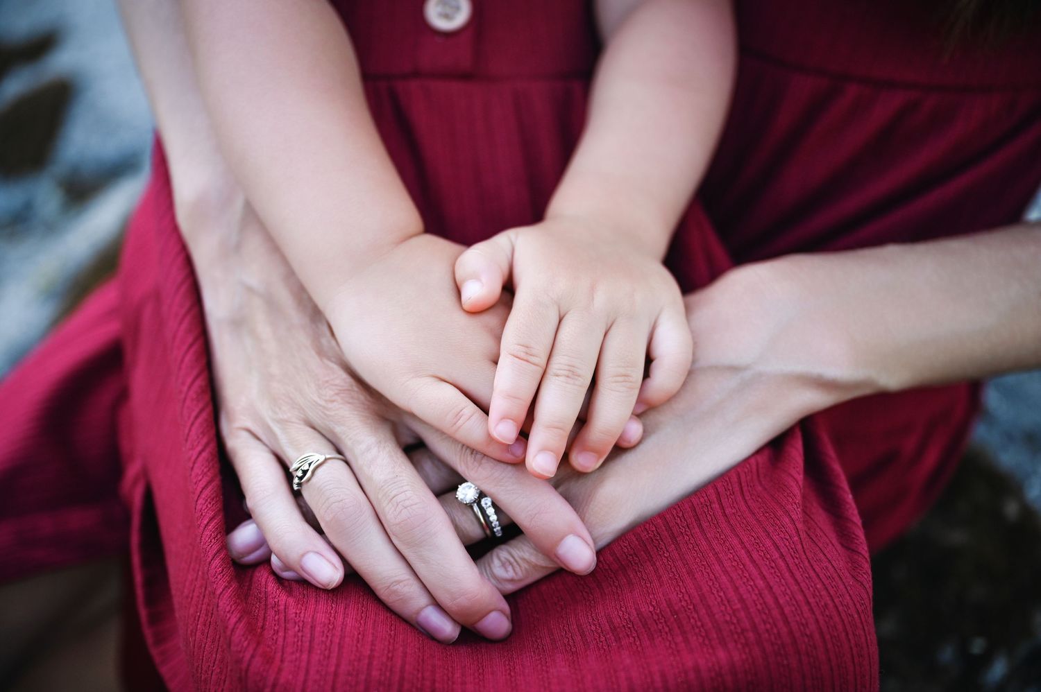 A series of cropped photos showing hands clasped together while wearing burgundy colored clothing. Fresno Family Photography