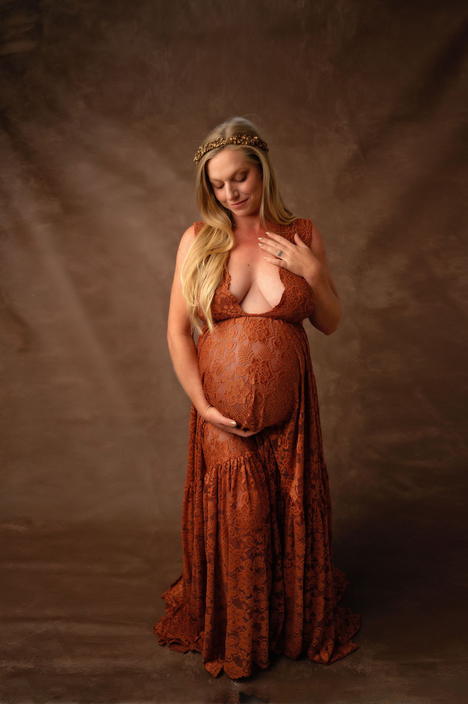 Maternity portrait in rustic brown lace dress against textured backdrop. Fresno Maternity Photographer