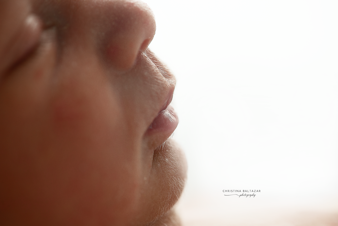Artistic close-up profile view of lips and nose against light background.
