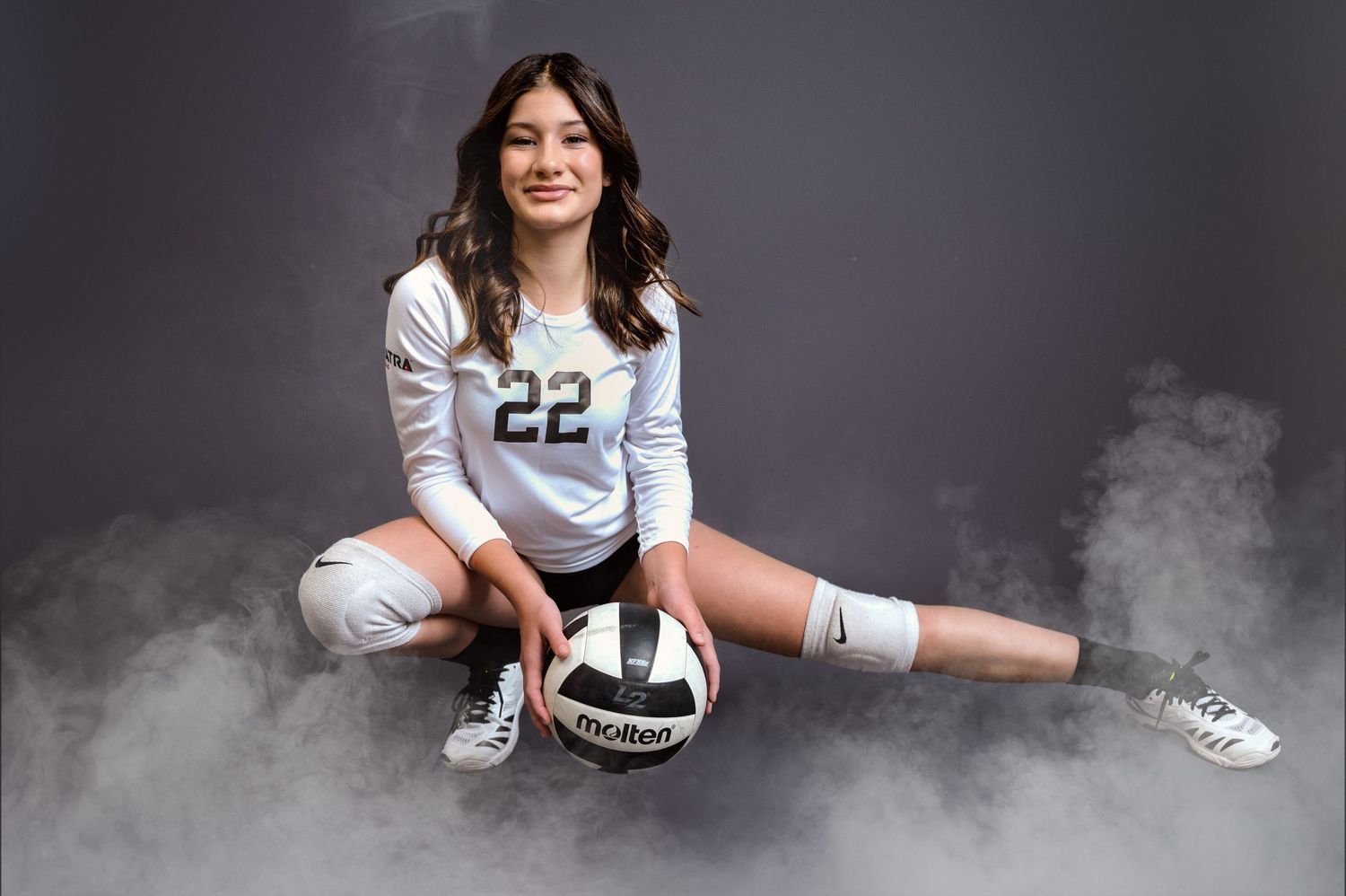Teen girl in vollyball uniform holding volleyball