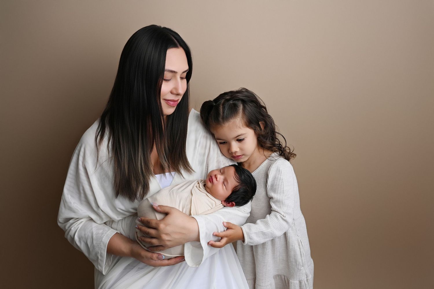 Intimate family maternity session with mother and child in white clothing.