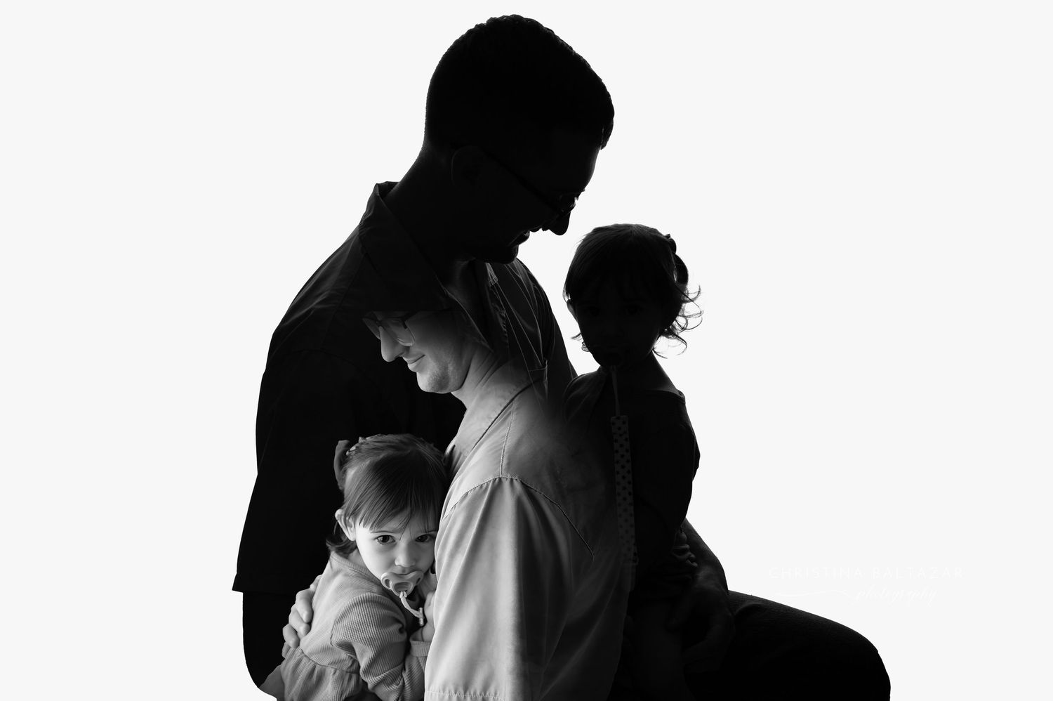 Black and white silhouette of family members standing together in an artistic portrait composition. Fresno Family Photography