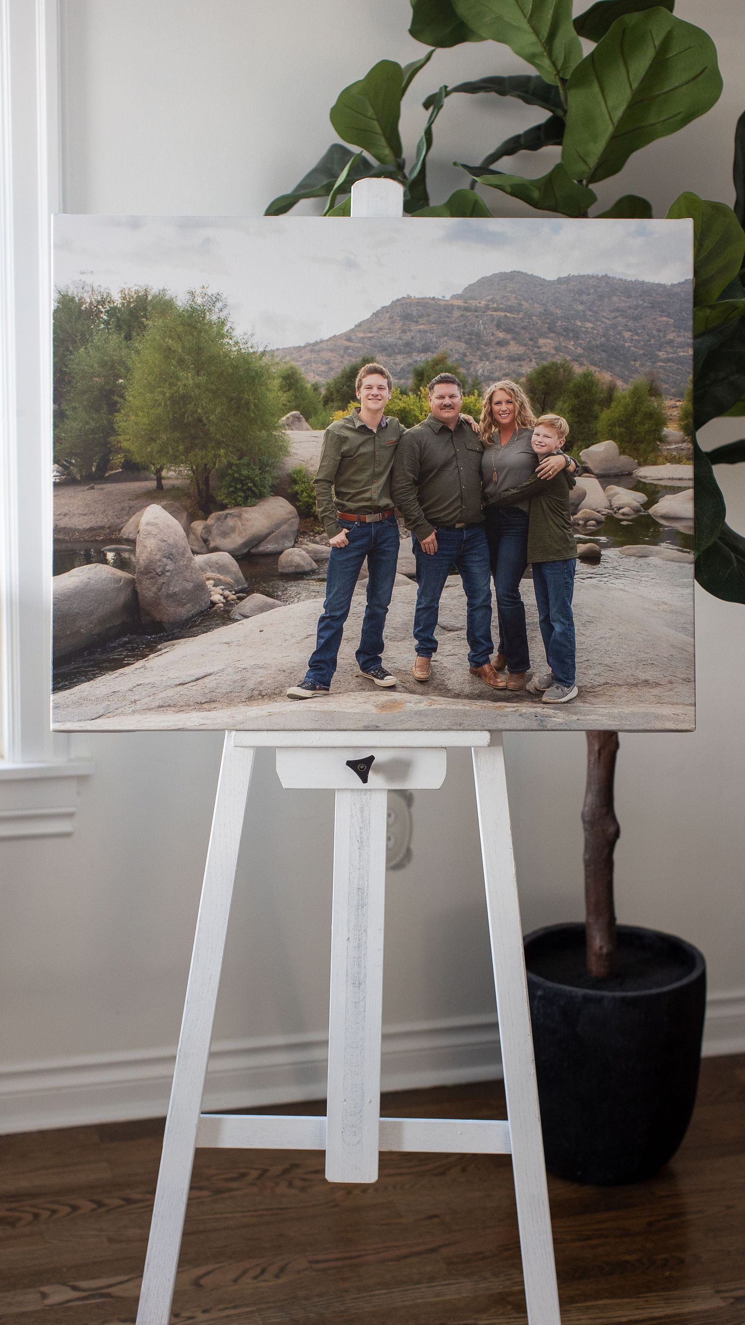 Canvas print on an easel showing a family group photo in front of mountain scenery. Fresno Family Photography