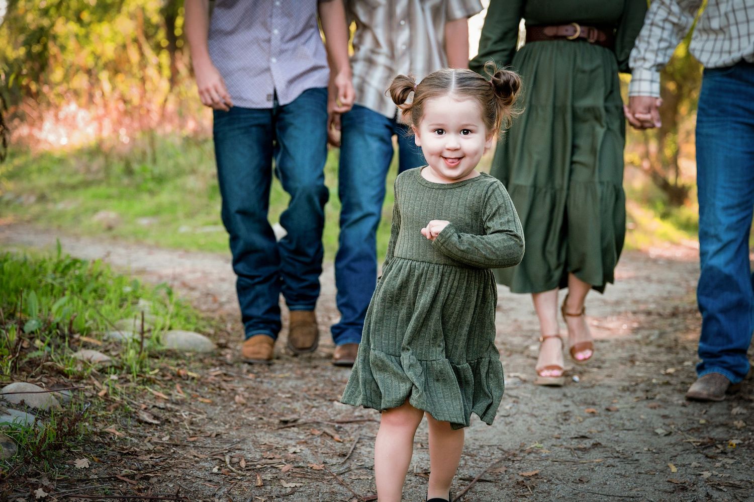 Family members walk together on dirt path through autumn scenery. Hanford Family Photographer