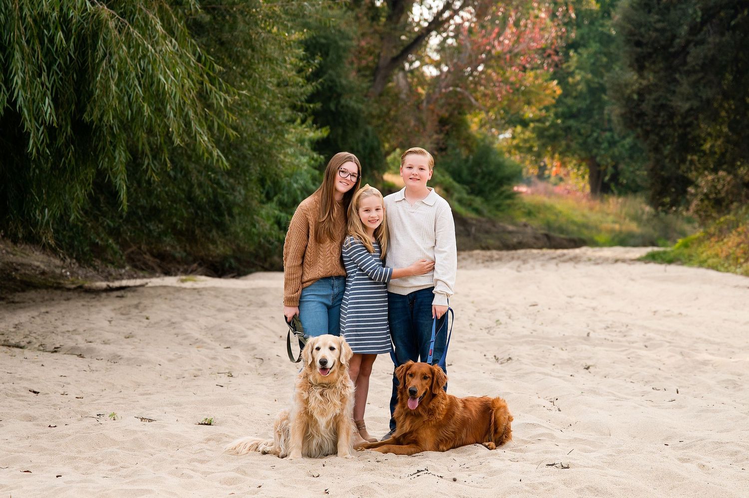 Family portrait session on a sandy beach with a dog during golden hour. Hanford Family Photographer