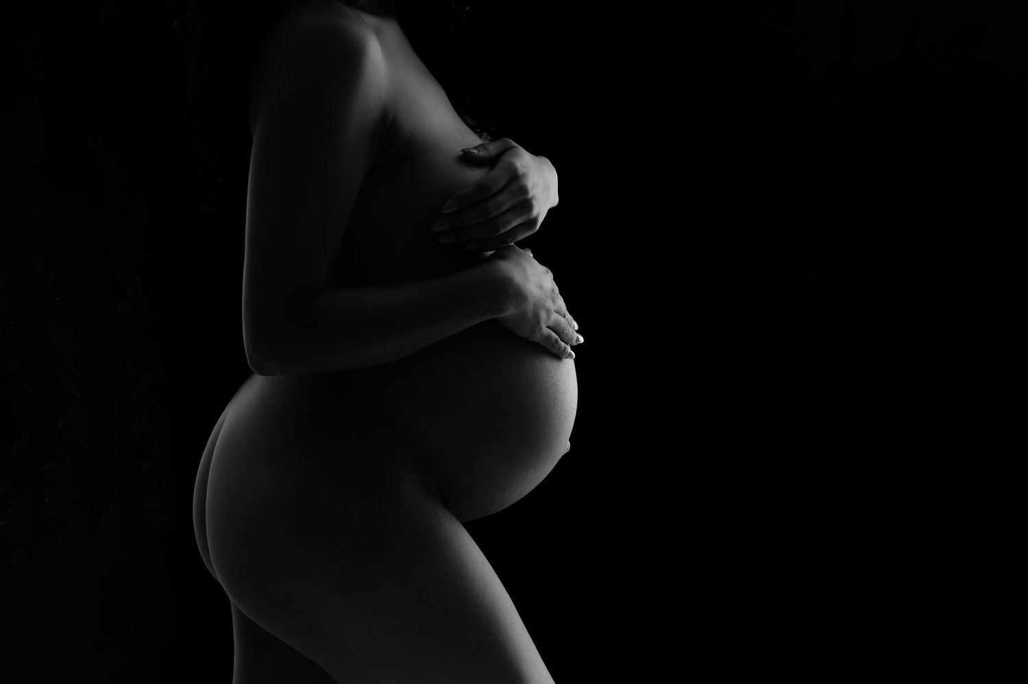 Minimalist black and white maternity silhouettes highlighting pregnancy curves.