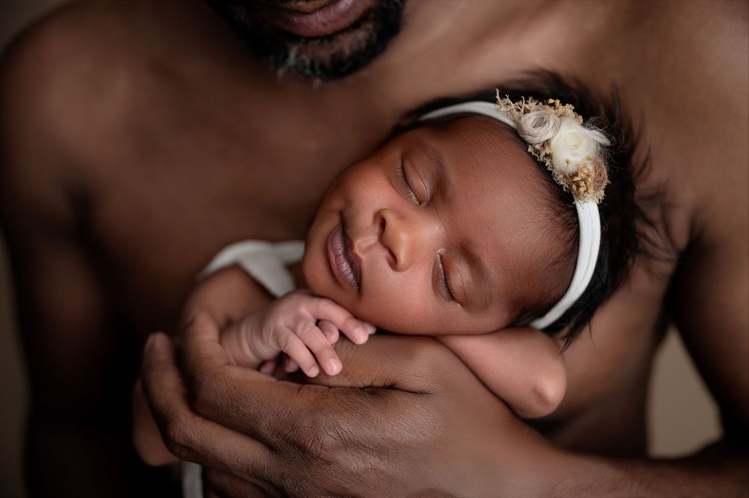 Intimate black and white photographs capturing gentle parent-baby interactions.