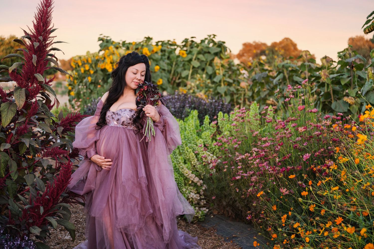 A flowing mauve dress creates an ethereal look among blooming wildflowers at sunset.
