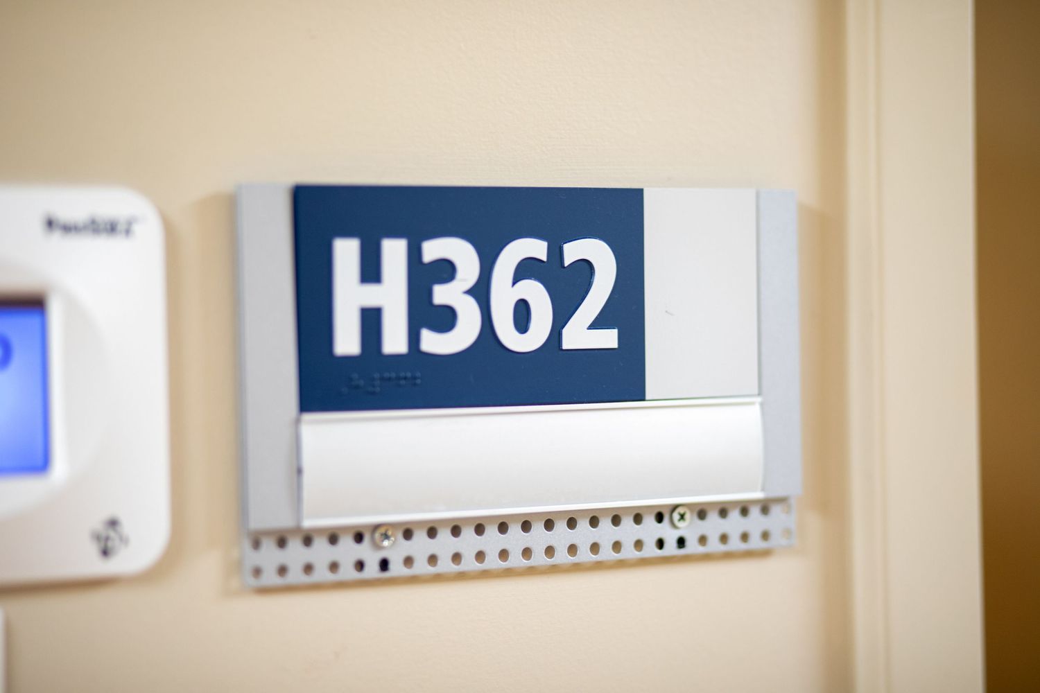 Hospital room number H362 displayed on wall mounted sign.