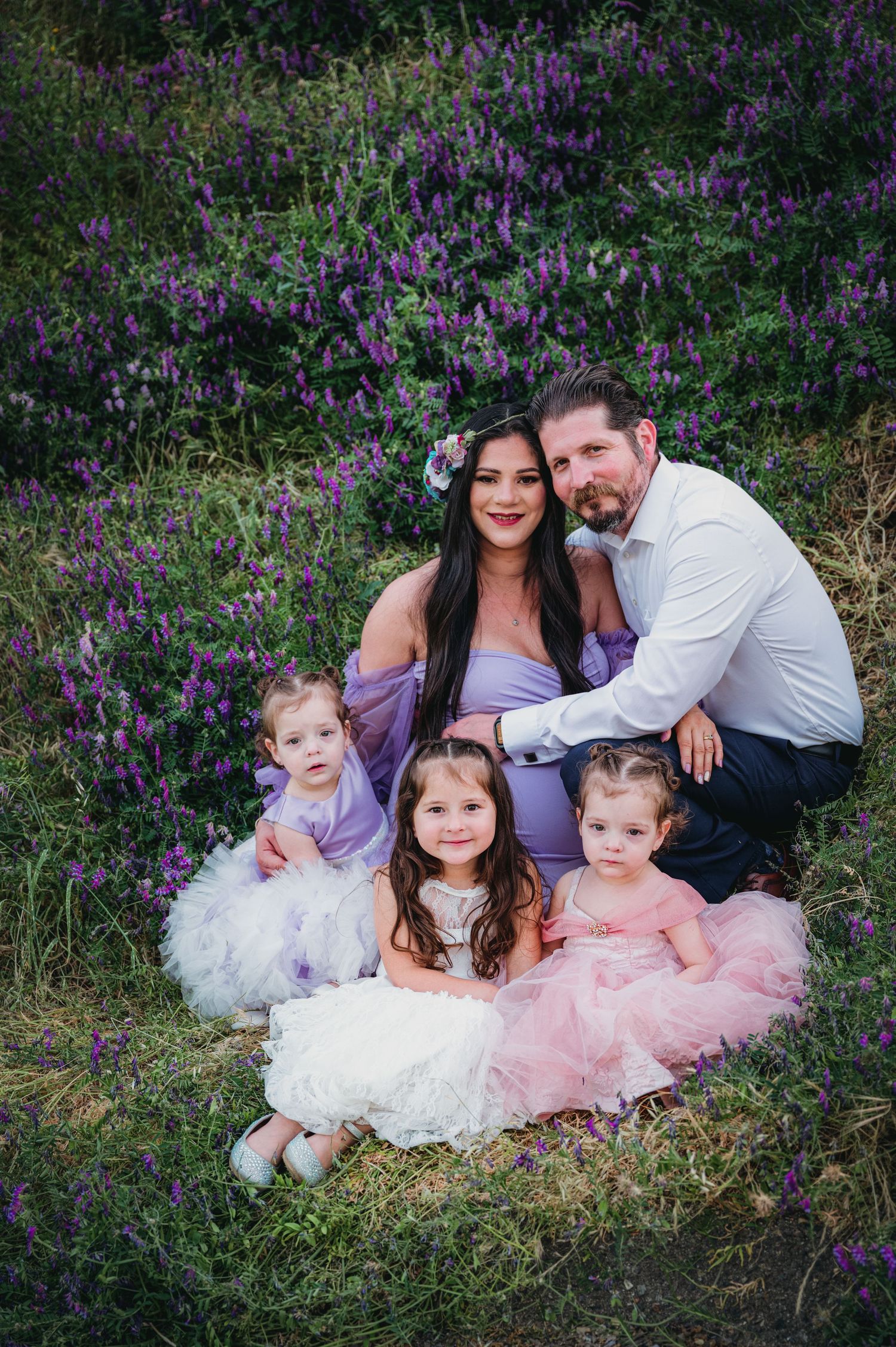 Family portrait with three children in tulle dresses among purple wildflowers. Hanford Maternity Family Photographer