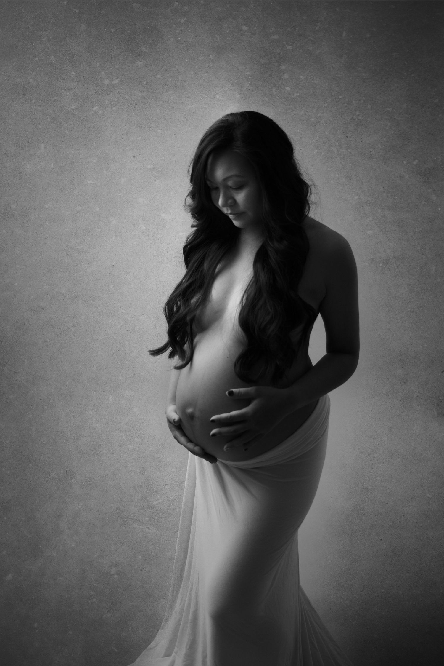 Artistic black and white maternity photos showing silhouette of pregnant belly.