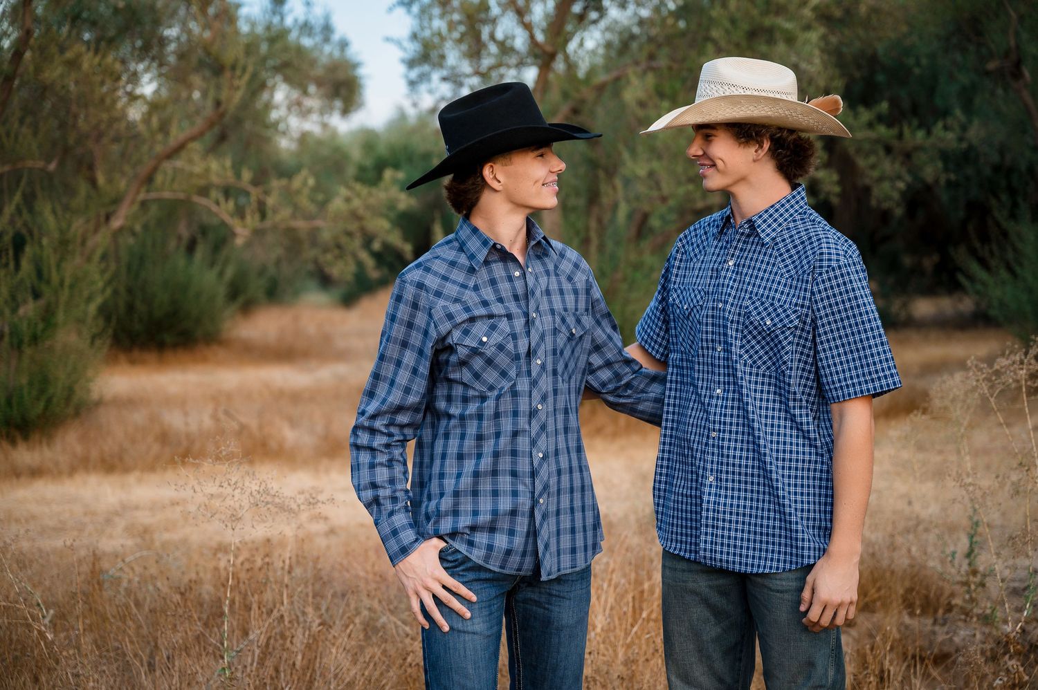 Two people in matching blue plaid shirts posing in a rustic outdoor setting. Hanford Family Photographer