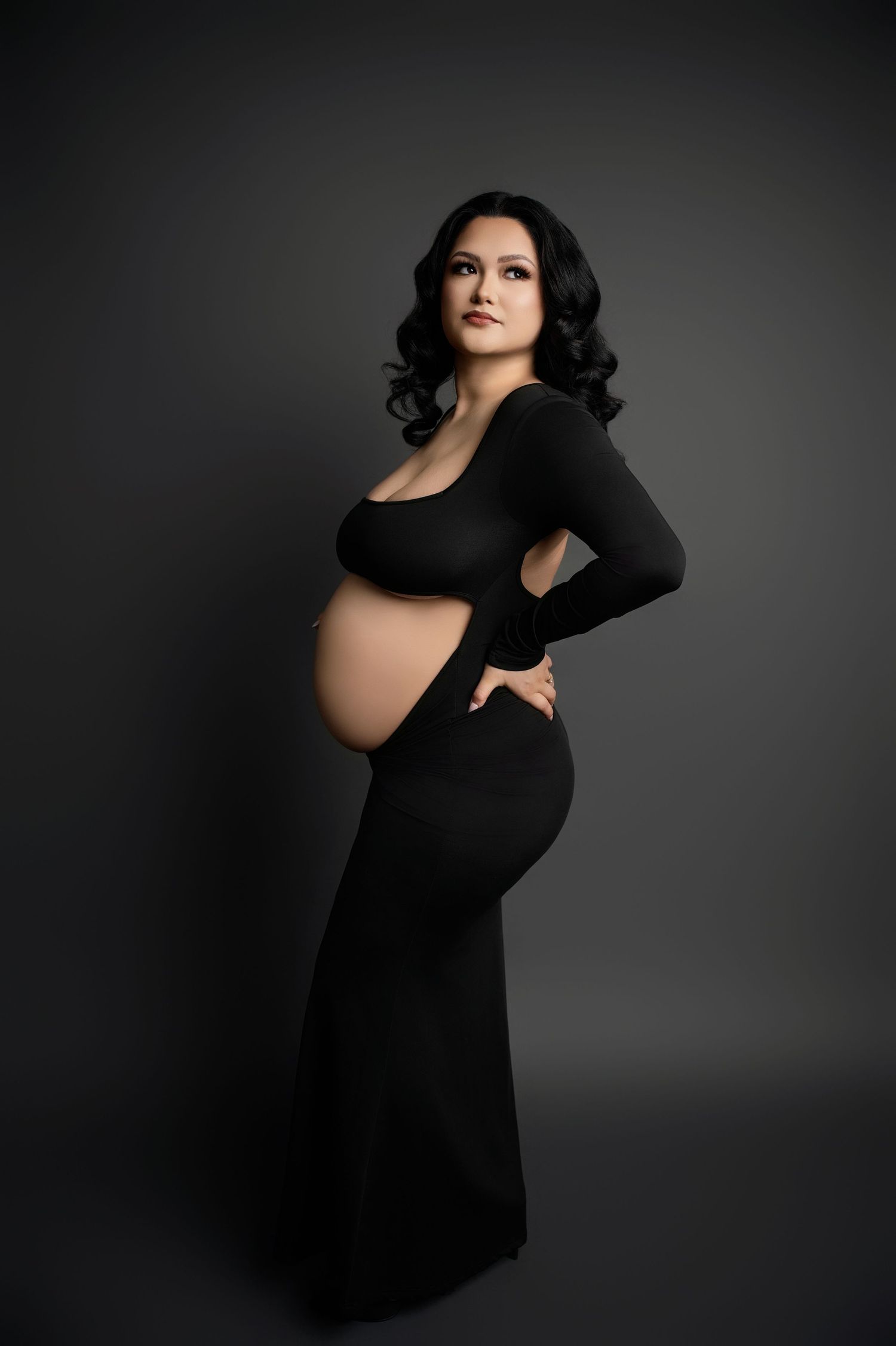 Artistic maternity portraits feature flowing black fabric and dramatic studio lighting.