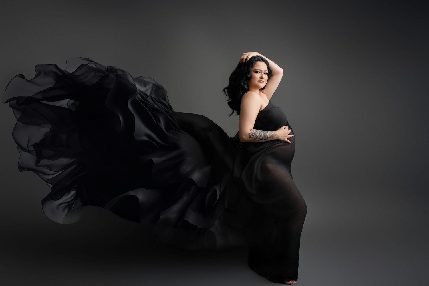 Flowing black fabric creates dramatic movement in these artistic maternity silhouettes.