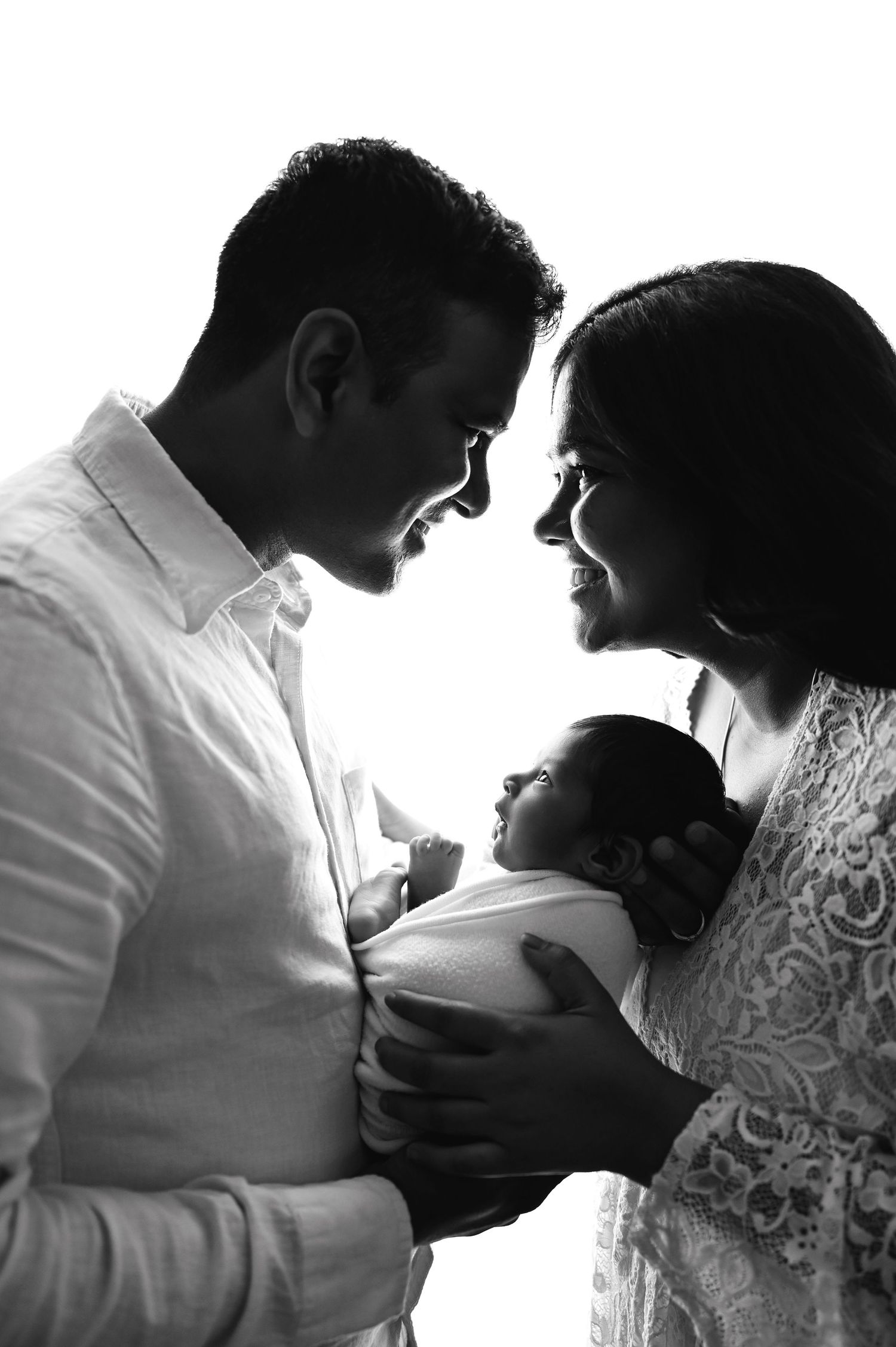 Artistic black and white newborn photography session showing intimate family moments.