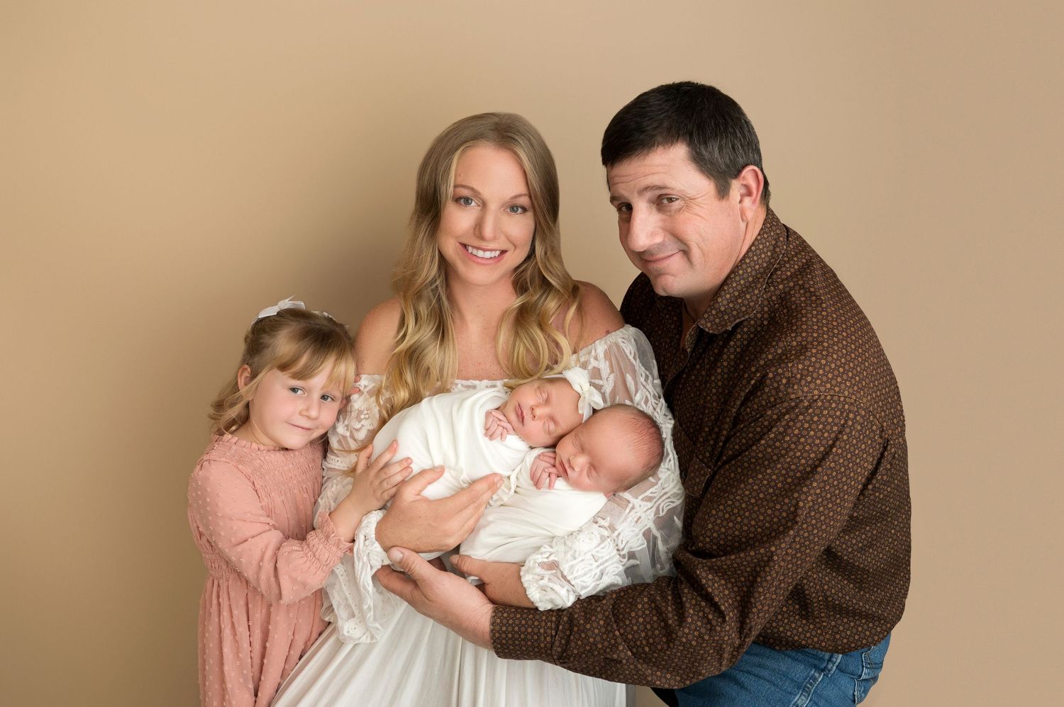 Family portrait session with parents and children on beige background.