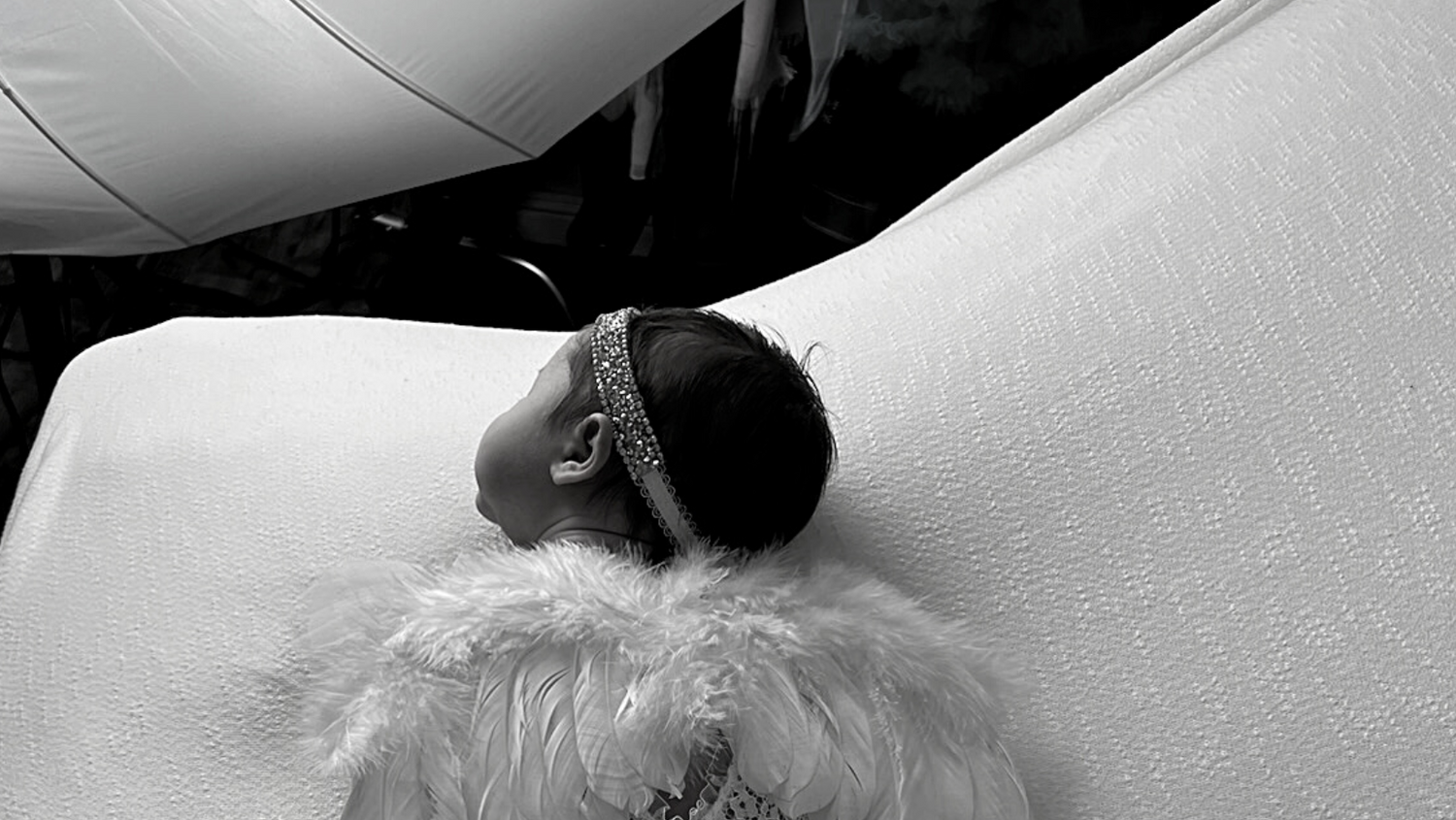 Black and white artistic portrait of sleeping newborn with soft textures.