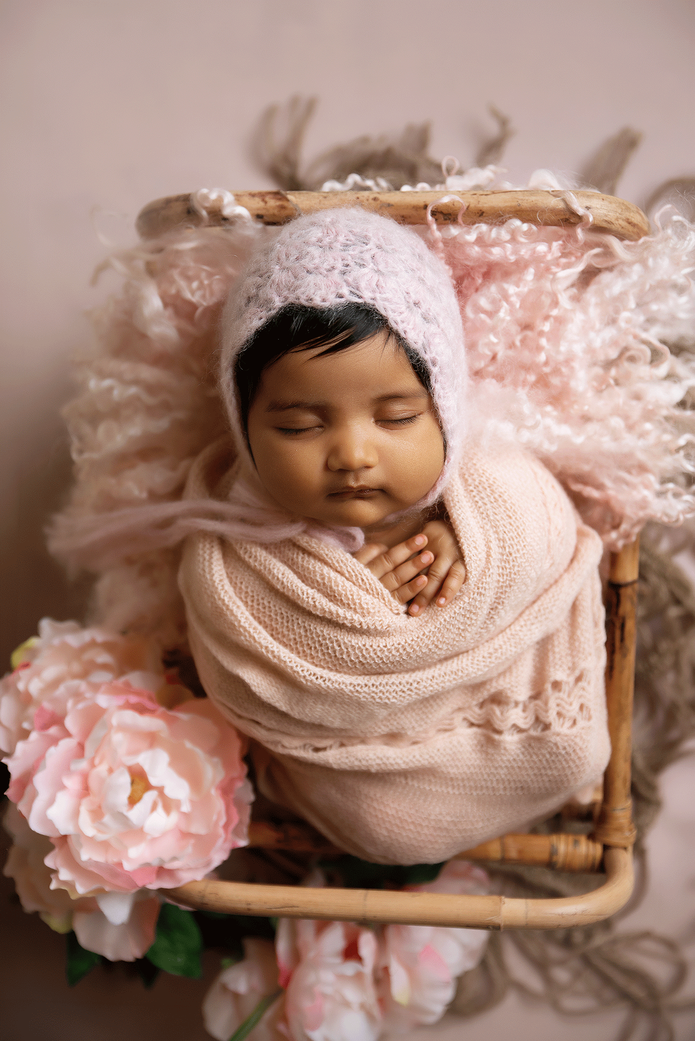 Peaceful newborn portrait, soft pink tones and delicate floral accents in a Lemoore newborn photography session