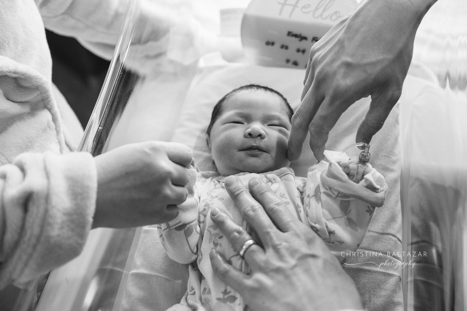 Black and white Fresh 48 photograph shows parents holding their newborn baby's hands. Hanford Fresh 48 Photographer