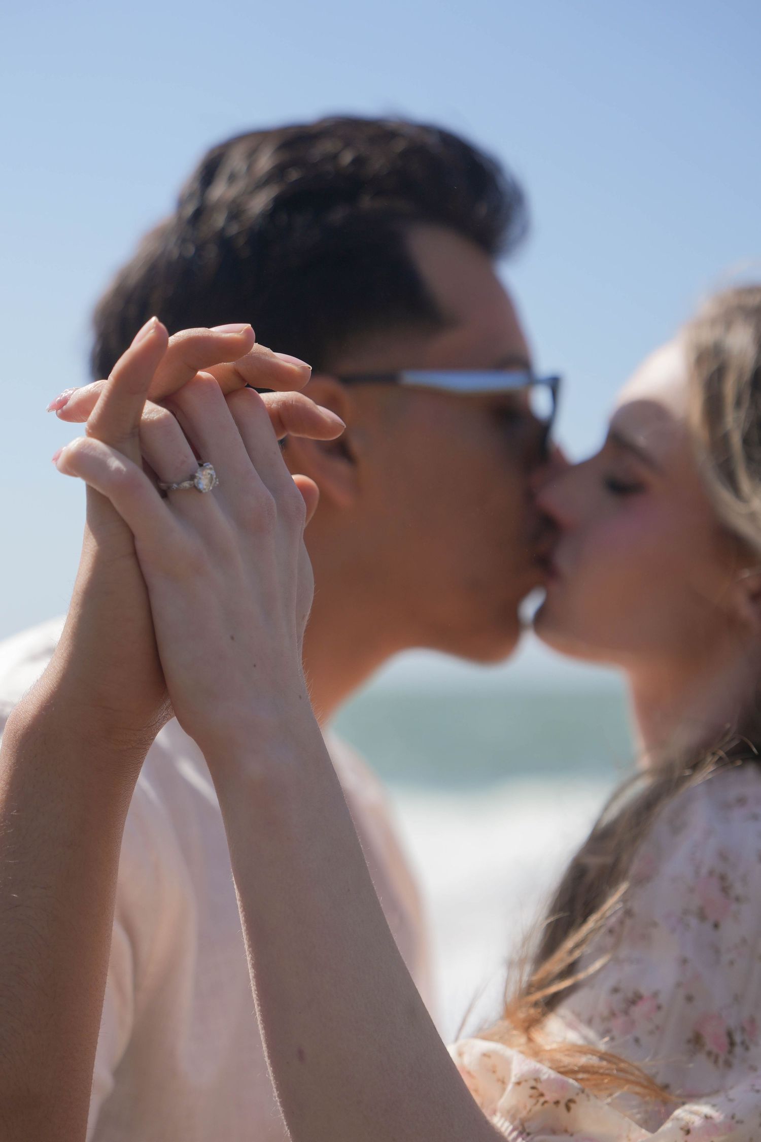 Close-up of couple holding hands and sharing intimate moment at beach.
