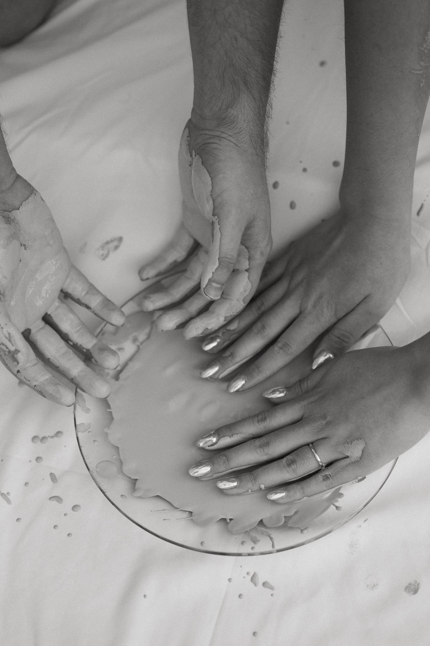 Black and white sequence showing hands kneading and shaping clay on a pottery wheel.