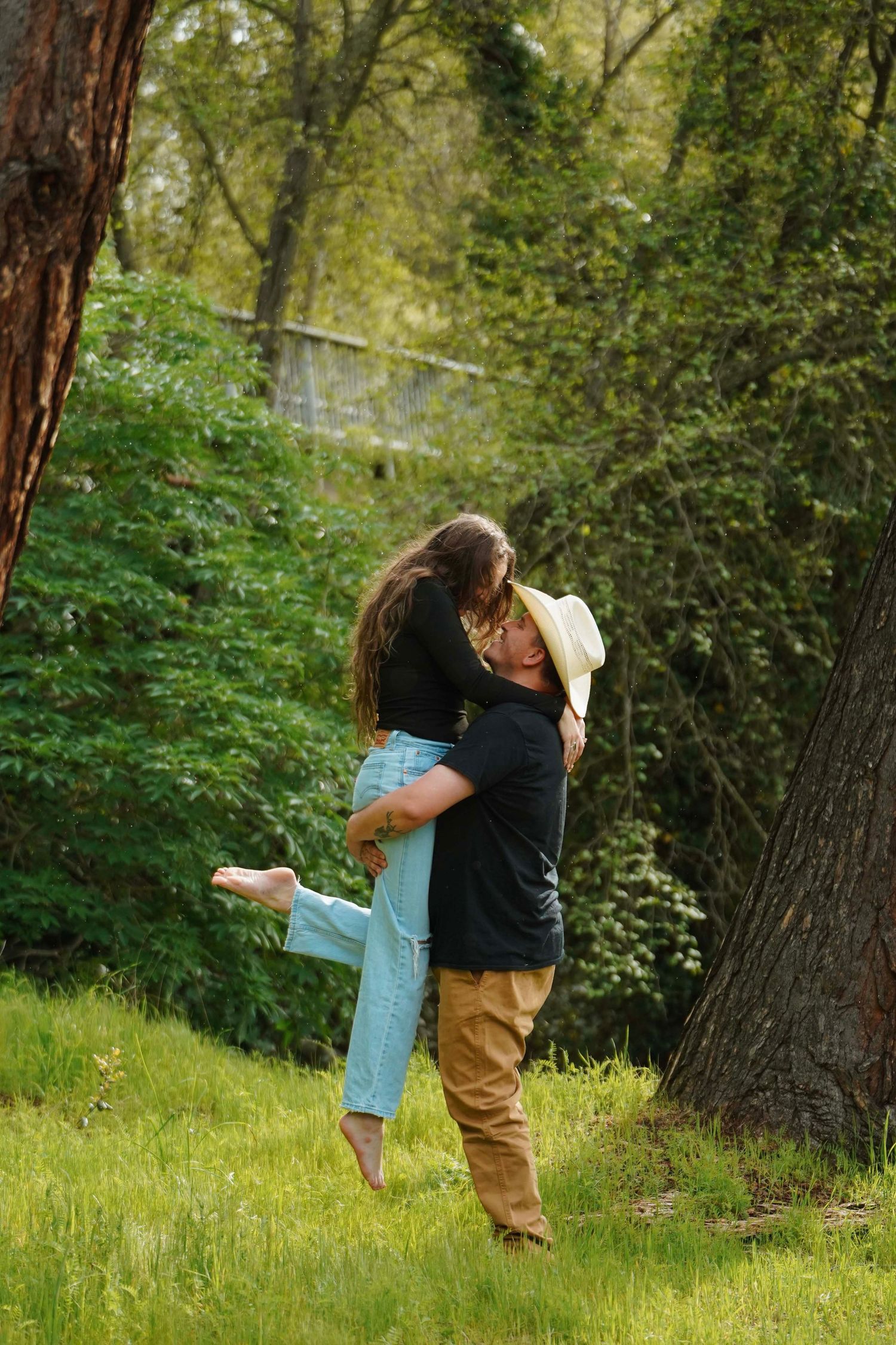 Romantic couple sharing tender moments in a lush green forest setting.