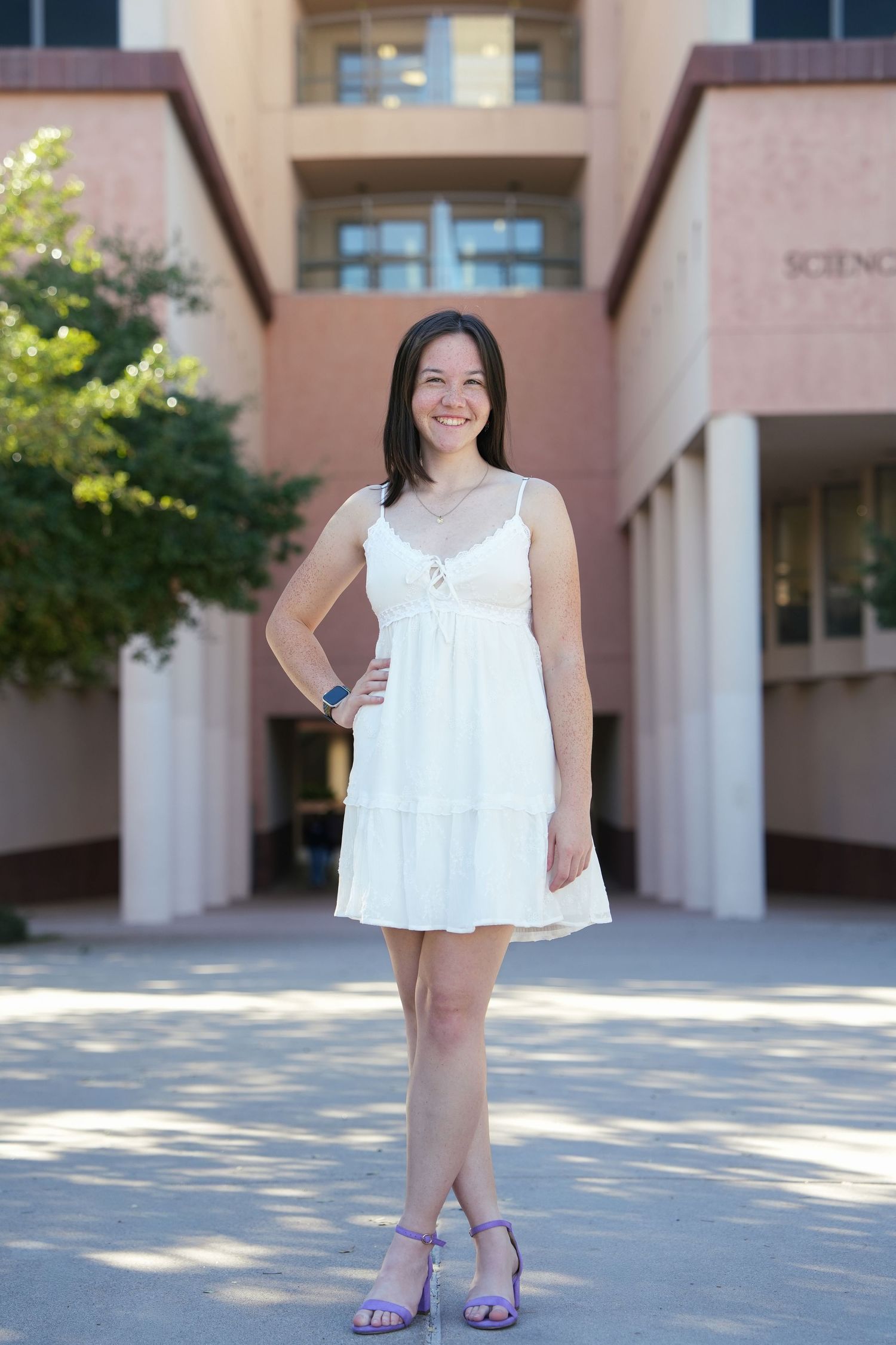 A child in a white summer dress poses outdoors against a beige building wall in multiple similar shots.