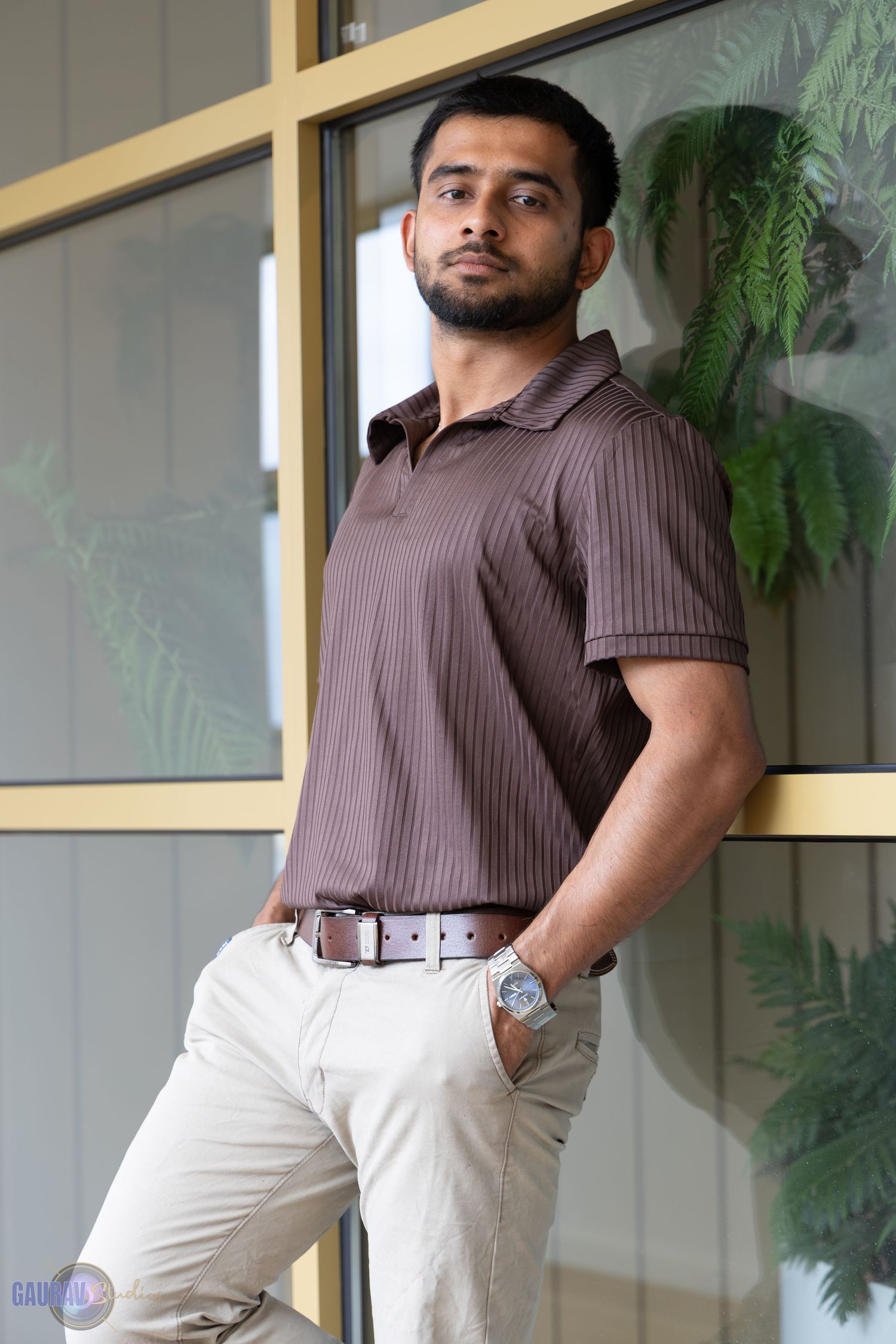 “Portrait of a man posing indoors, standing casually with one hand in his pocket.”