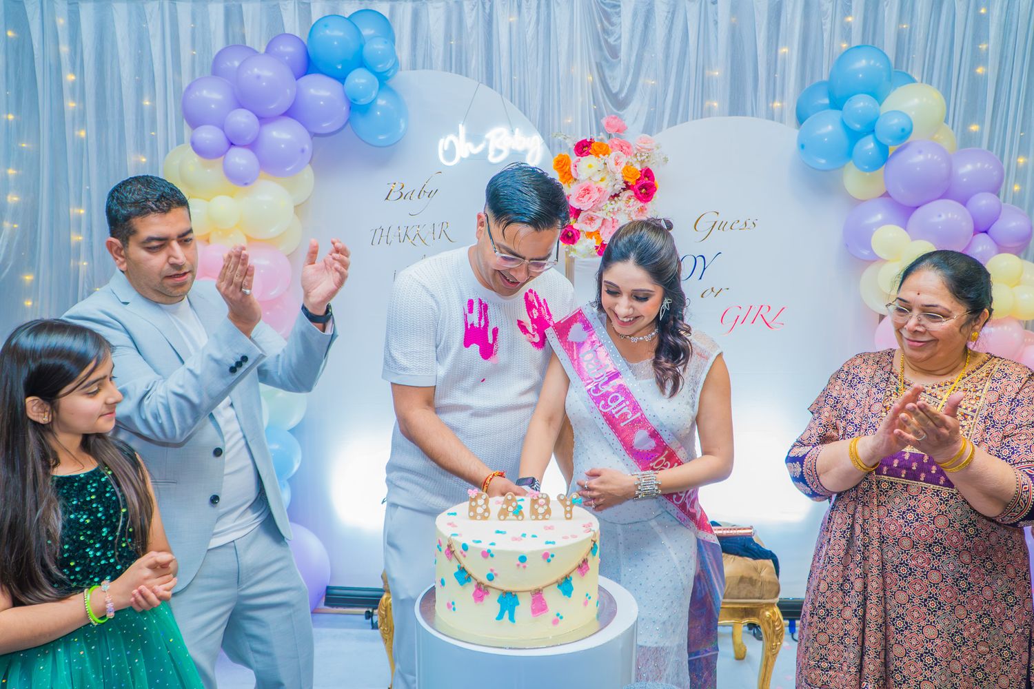 “Family and friends celebrating a birthday and cutting a decorated cake at an outdoor party.”