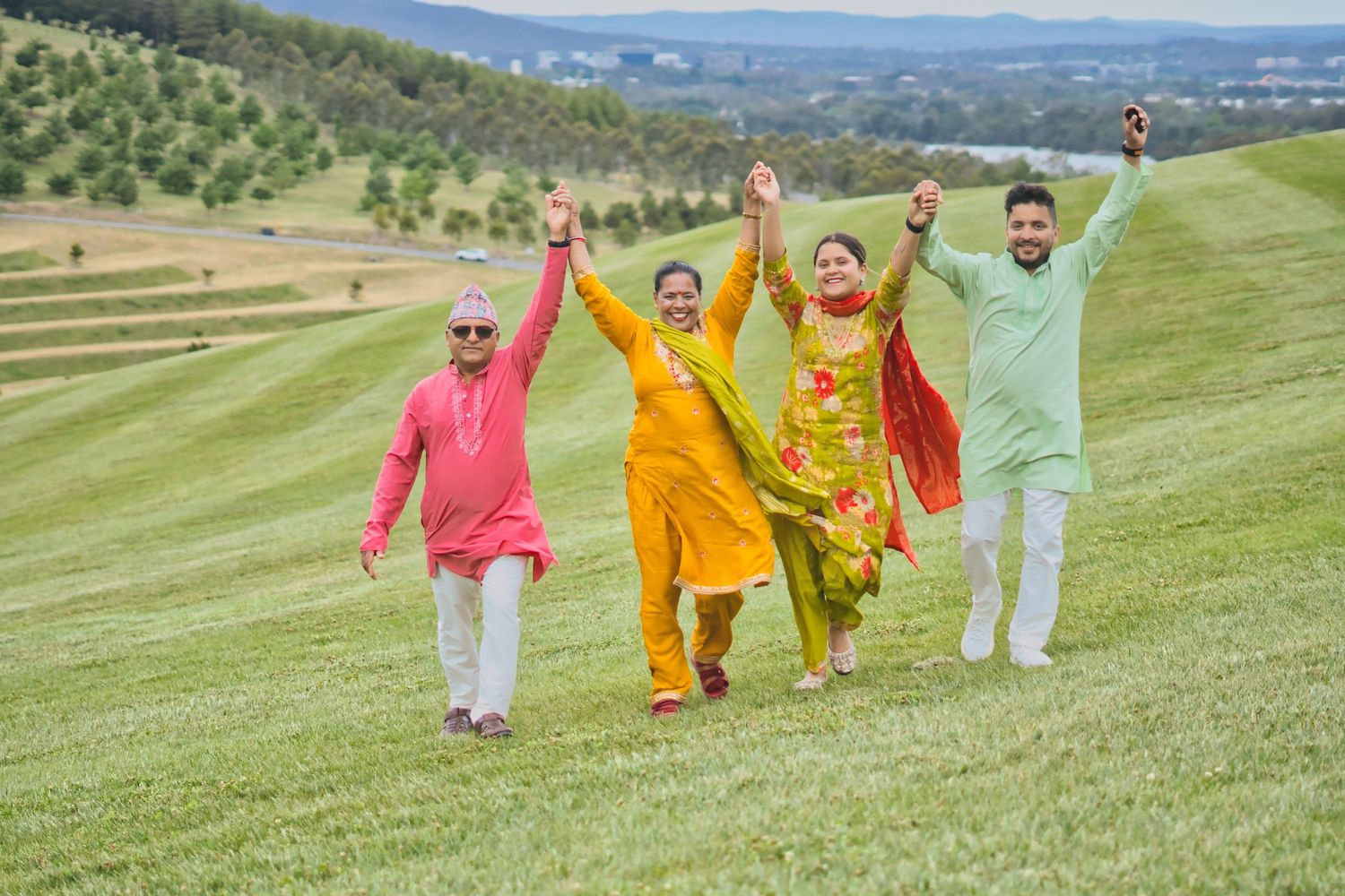 “Group of people in traditional clothing walking across a green field on a sunny day.”